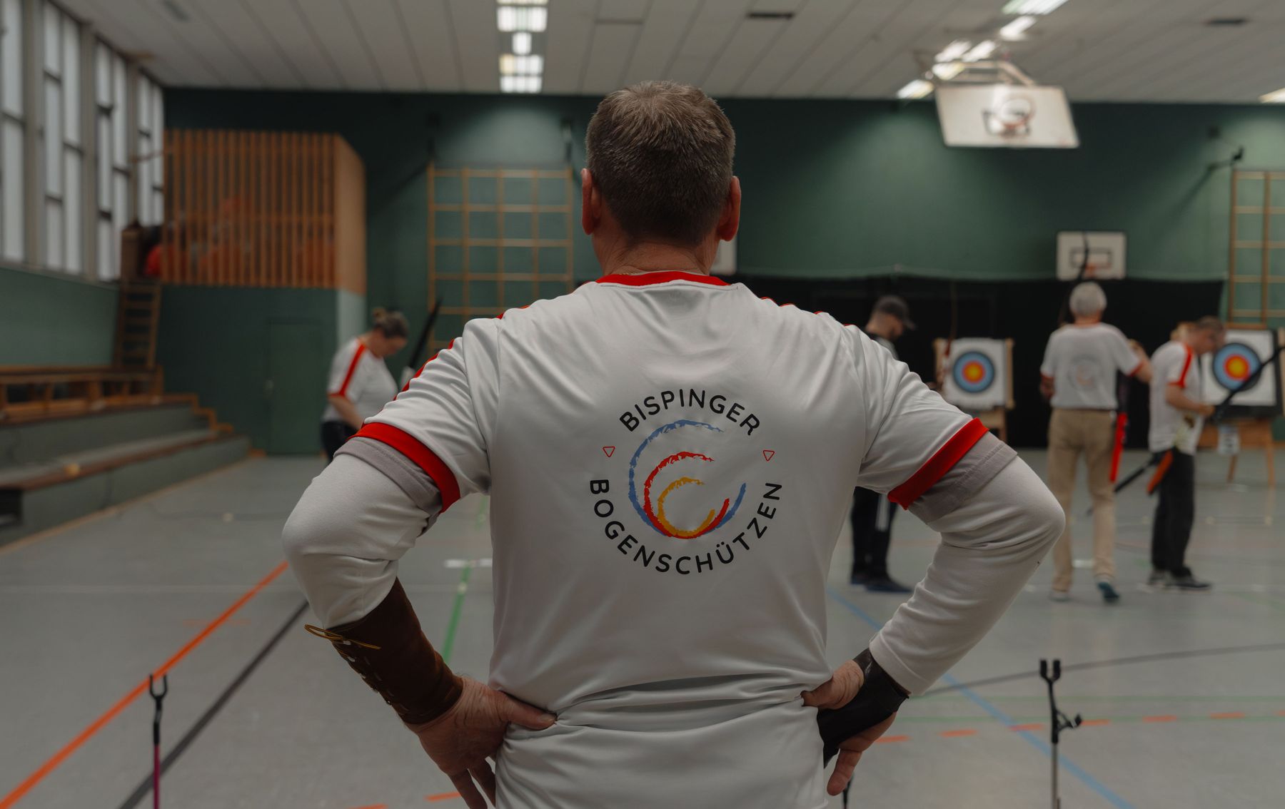 Bogenschütze im Vereinstrikot von hinten beim Hallentraining